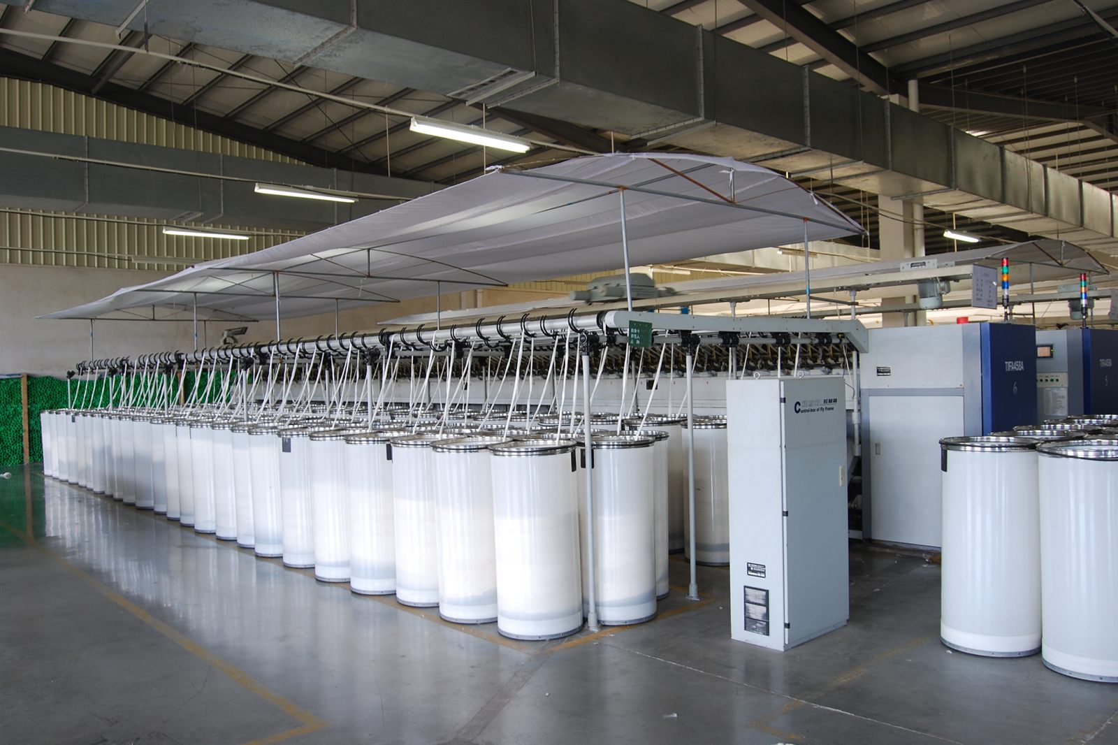 Spinning hall with sliver cans feeding the creel frames